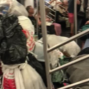 Trash bags and trash in subway car man sleeping