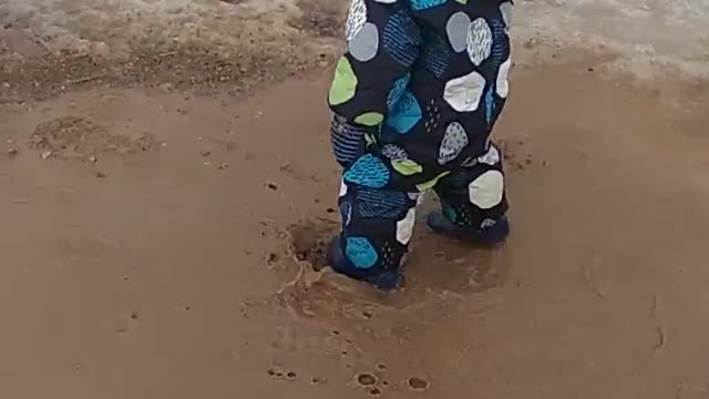 Happy childhood: boy and puddle