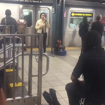 Woman sings man plays drums subway