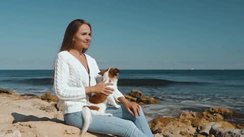 Young adult woman spending day on beach with little dog