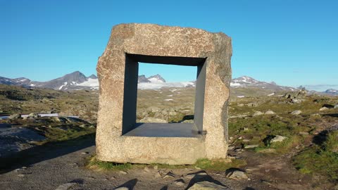 Square cut out of a granite block of stone over the mountains