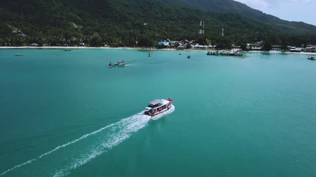 Beautiful coast with motorboats and a pier seen from the air