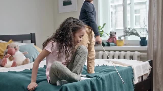 Children play bait catch with their cat in bedroom#short video