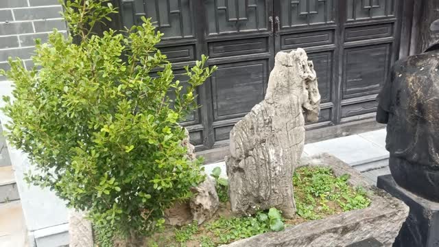 A horse like stone behind a cowboy