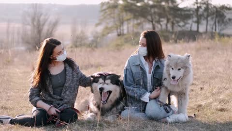 Women With Face Masks Petting Dogs