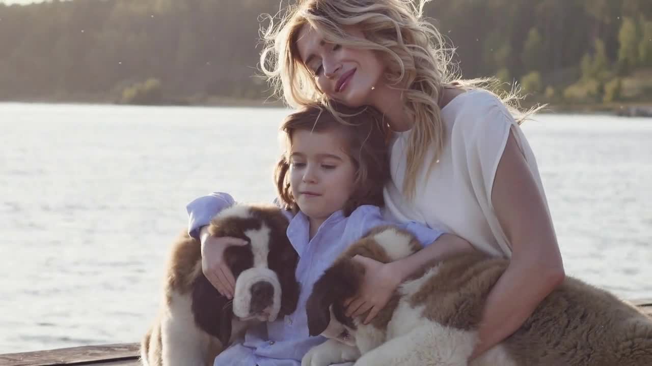 Little boy with mother near the sea playing with their dogs