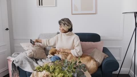 Woman Using Cellphone while Playing the Dog