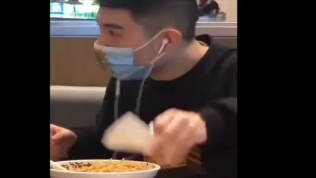 Guy forgets he has a mask on and while eating noodles