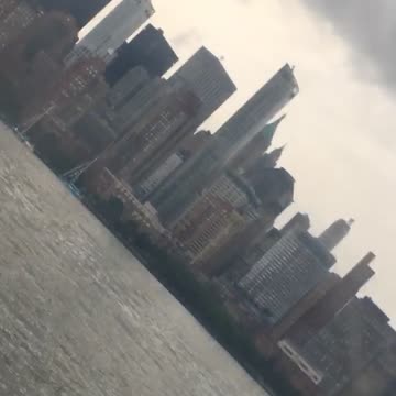 A man in a suit paddle boards on hudson river in new york