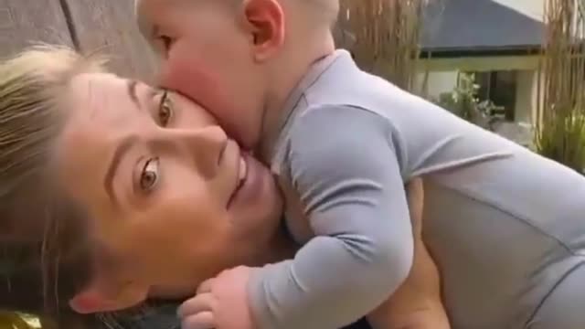 Beautiful baby bites her mother in a funny way