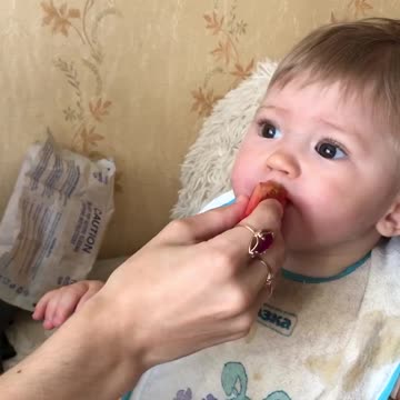 Child eating sour tomato