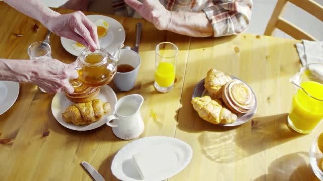 Pouring A Hot Tea On A Cup As Part Of A Breakfast Set Meal