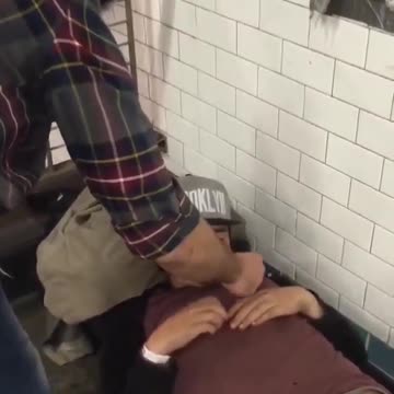 Guy lights up a homeless mans cigarette while he is sleeping