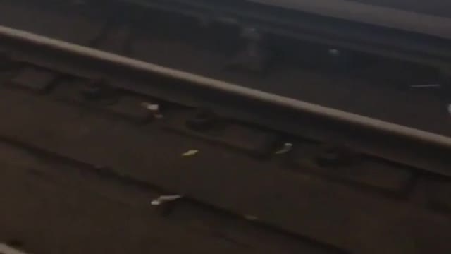 Baby shoes and wrist watch on a subway train track