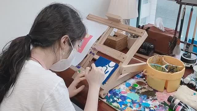 A woman painting in a studio