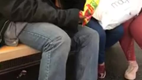 Man and woman smoking joint passing weed across subway