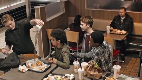 Teens mock a boy at Burger King, oblivious to a man sitting on a bench.