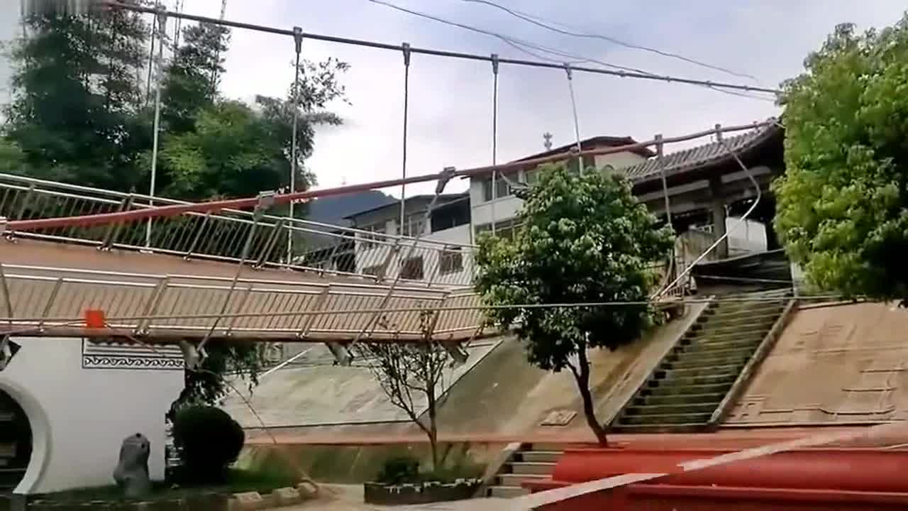 Pedestrians left stranded as suspension bridge swings onto its side in China