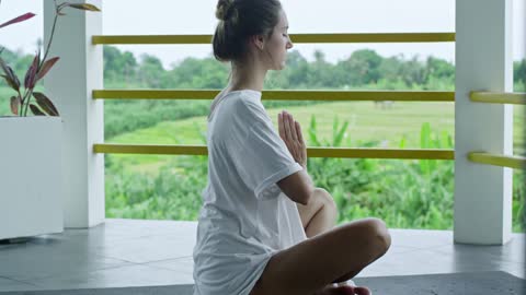 Woman Meditating On A Platform Overseeing The Rice Field