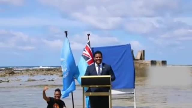 Tuvalu's foreign minister speaks while standing in the sea