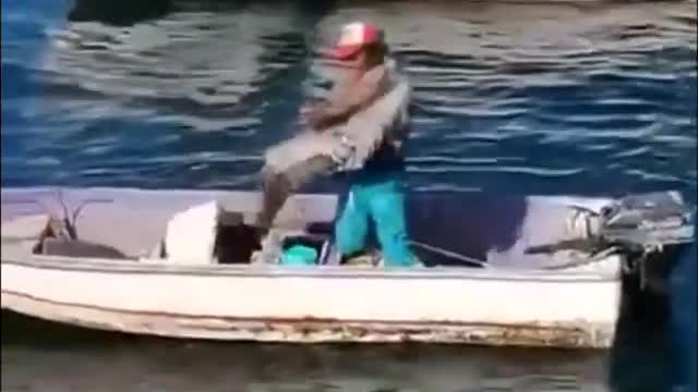 Fisherman gives pelican a friendly hug 😊