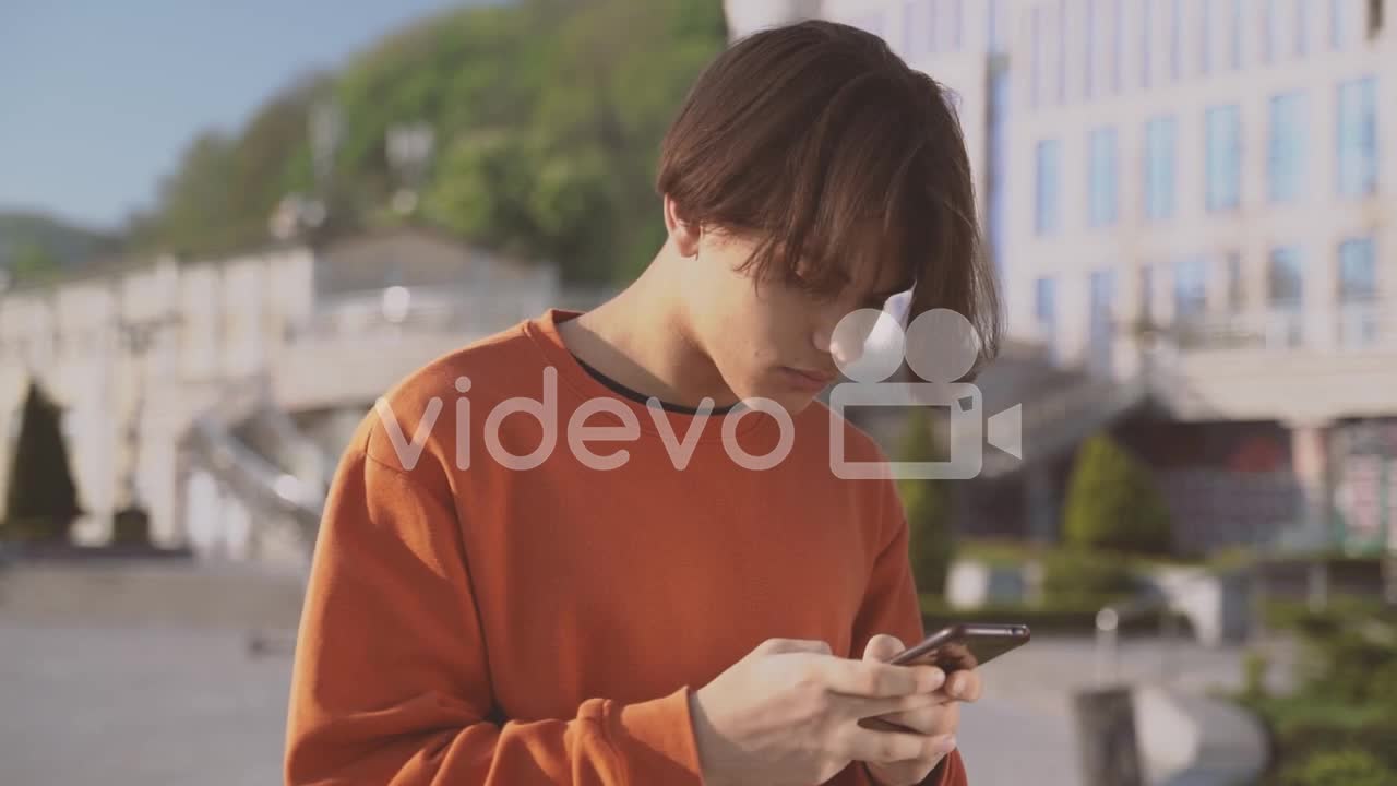 Teenager Sending A Message With His Cellphone