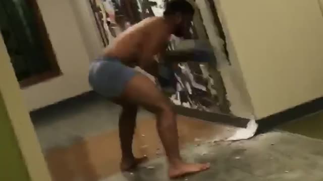 Shirtless guy black gloves punches holes in wall