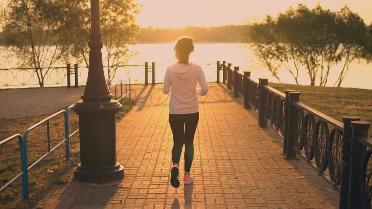 back view woman jogging with french bulldog in park slow motion