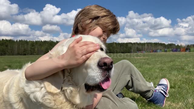 love for pets. little boy playing with his dog in sunny summer weather,