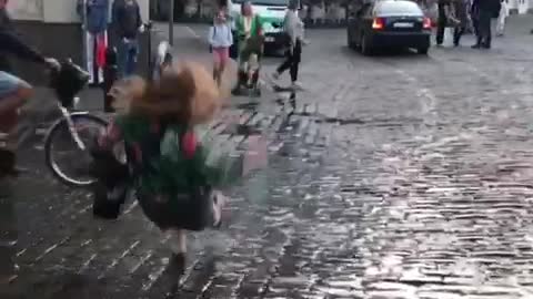 Woman in colorful jacket jumps in puddle and falls back