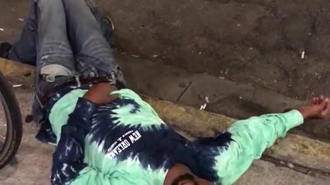 Video of guy enjoying a parade in new orleans then different guy is laying on the floor.