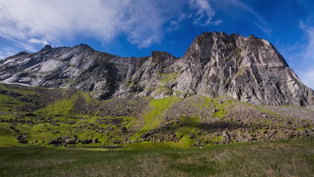 an establishing shot of the kjerringa mountaintop at kvalvika on norway