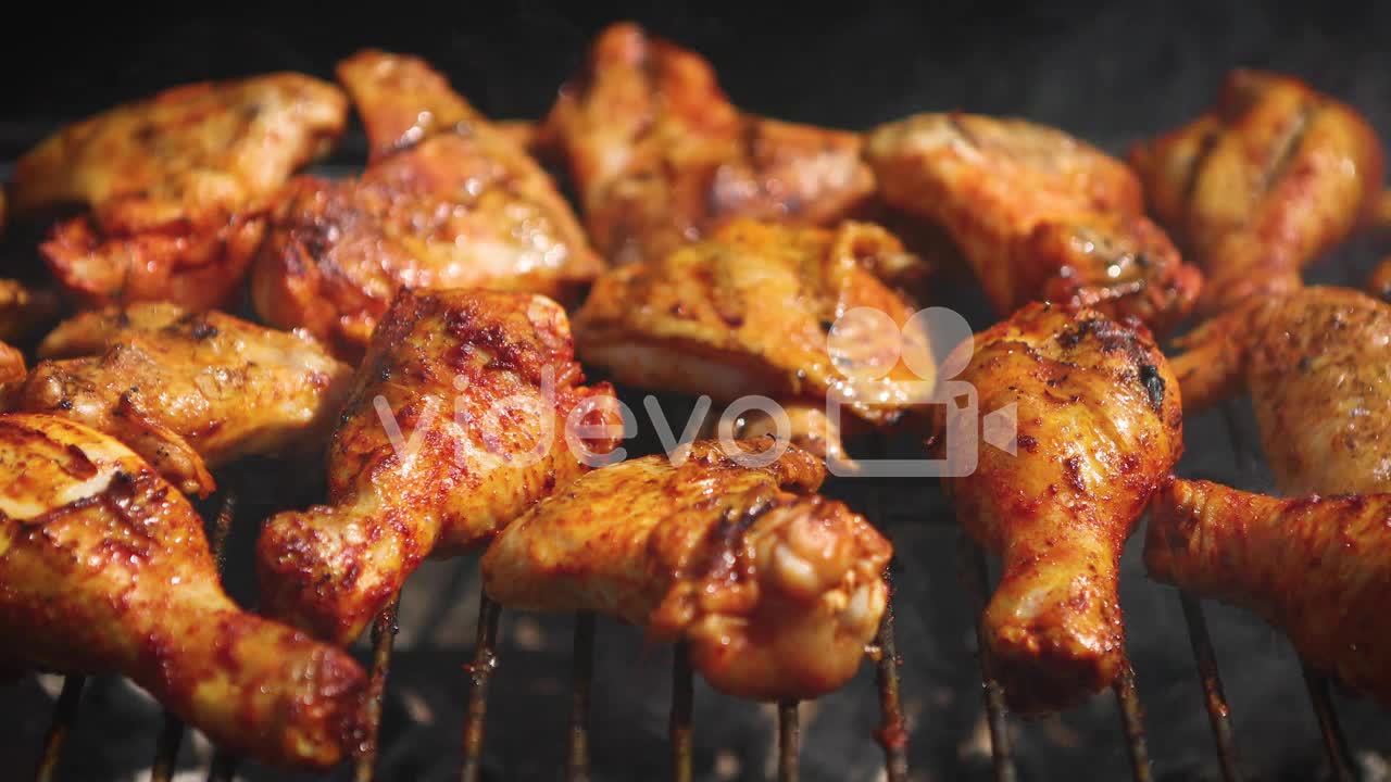 Delicious chicken pieces frying on barbecue grill