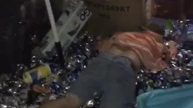 Guy pink shirt jumps into cans