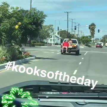 Red shirt guy riding on open trunk of truck