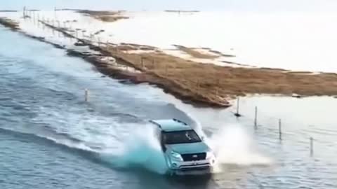 The road is flooded with water, but this is not a problem for an SUV