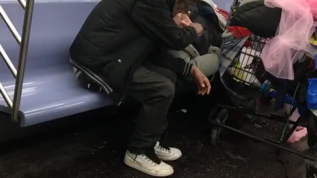 Couple smokes blunt on subway train, woman laying down on seat