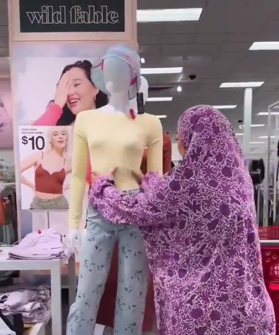 Muslim woman covers up a mannequin because it shows too much skin at a
