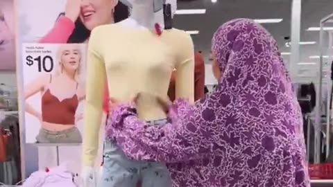 Muslim woman covers up a mannequin because it shows too much skin at a