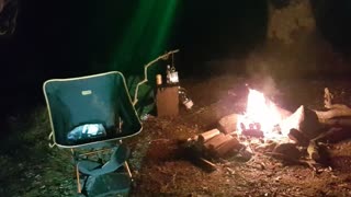 Position the camera ready for filming campfire vlog. Riverside wildcamping.