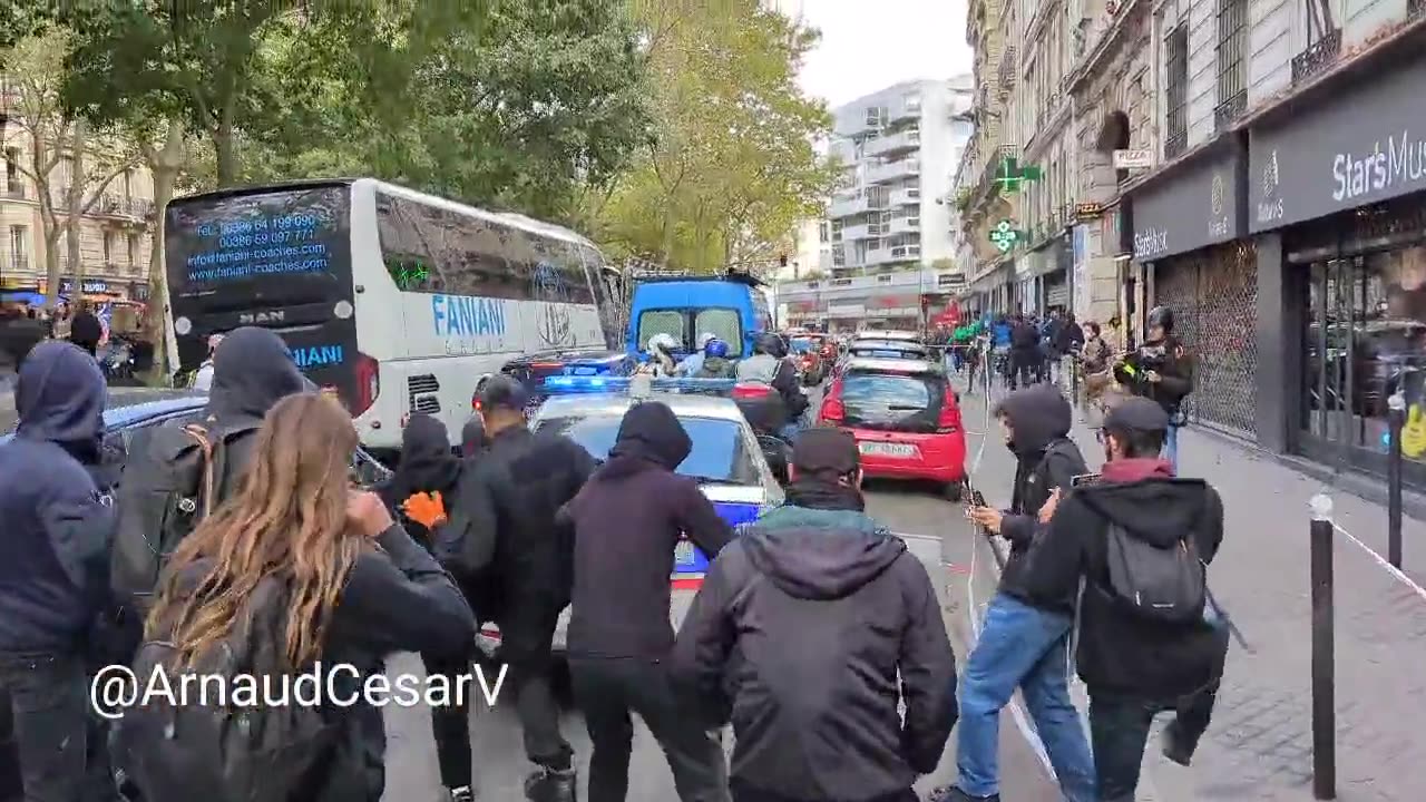 Un'auto della polizia viene presa di mira dai manifestanti a Parigi