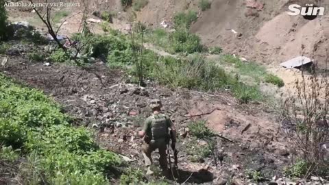 Ukrainian soldiers inspect scorched Russian tanks in Donbas