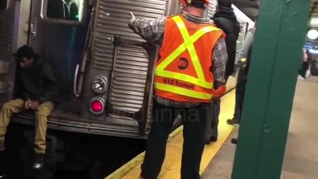 Sad guy sits on the edge of subway train and waits for train to go, attendants tell him to get off