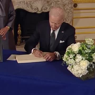 Biden takes out notes from his pocket to write & Sign in Book of Condolences