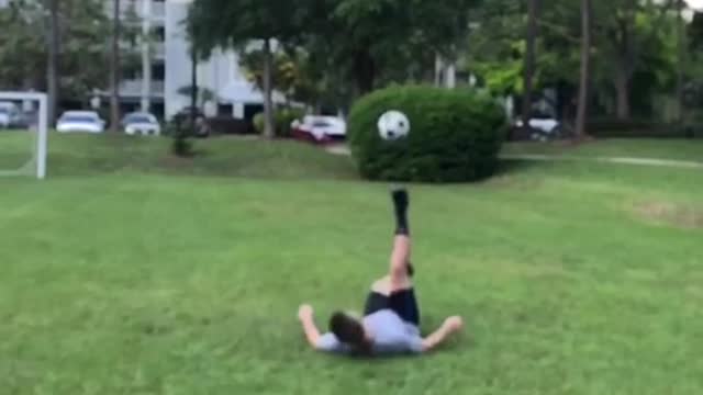 Guy tries to kick soccer ball but kicks ball into his own face