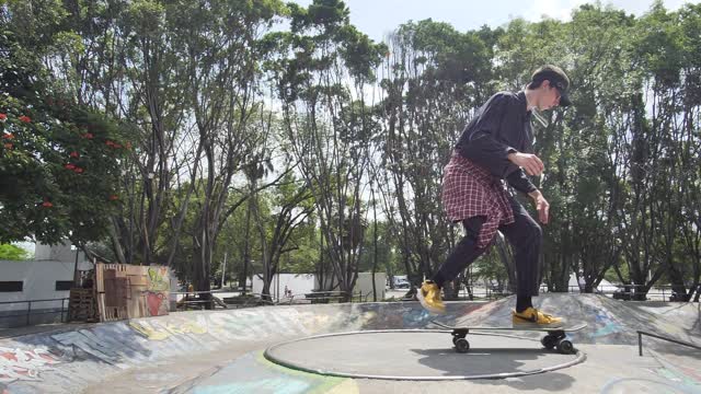 Boy doing a pirouette with a skateboard in a park