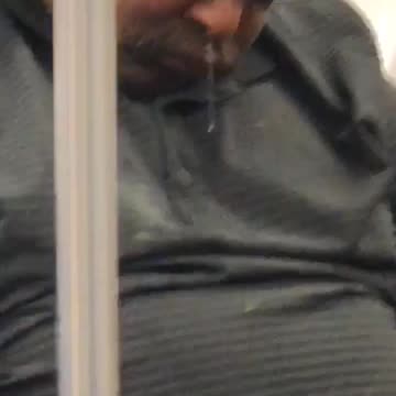 Man asleep in grey shirt has snot coming out of nose