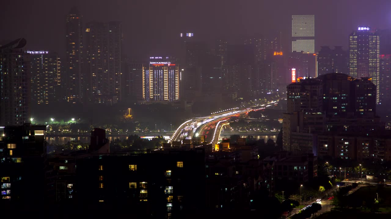 City covered with buildings and cars at night