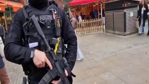 Charlie Veitch talking to armed police at Xmas market.
