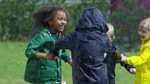 children-playing-in-a-park-getting-wet-by-the-rain